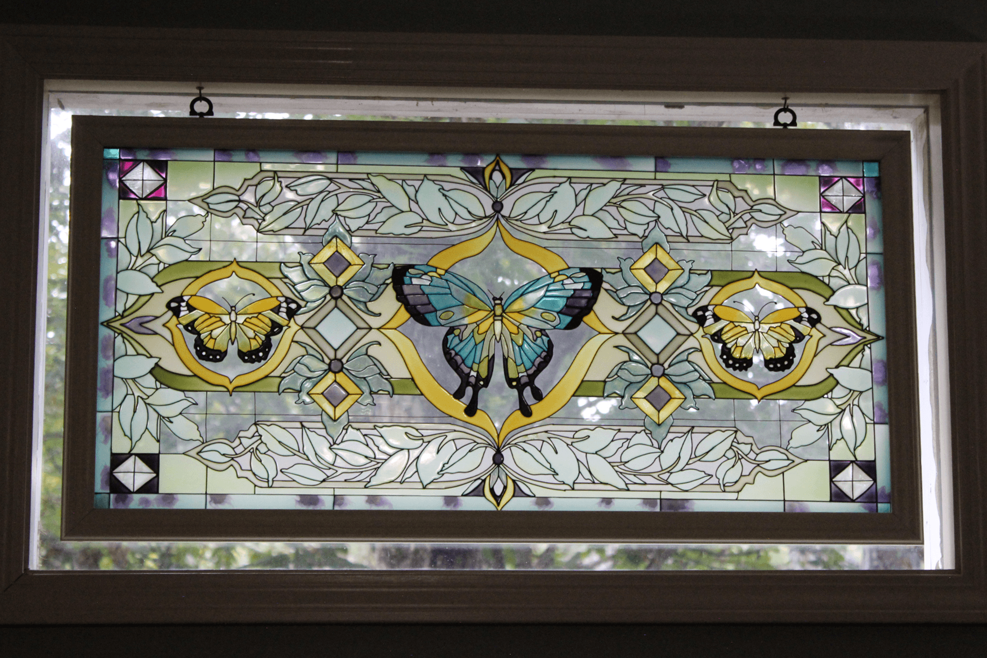 Stained glass window featuring colorful butterflies and floral patterns.